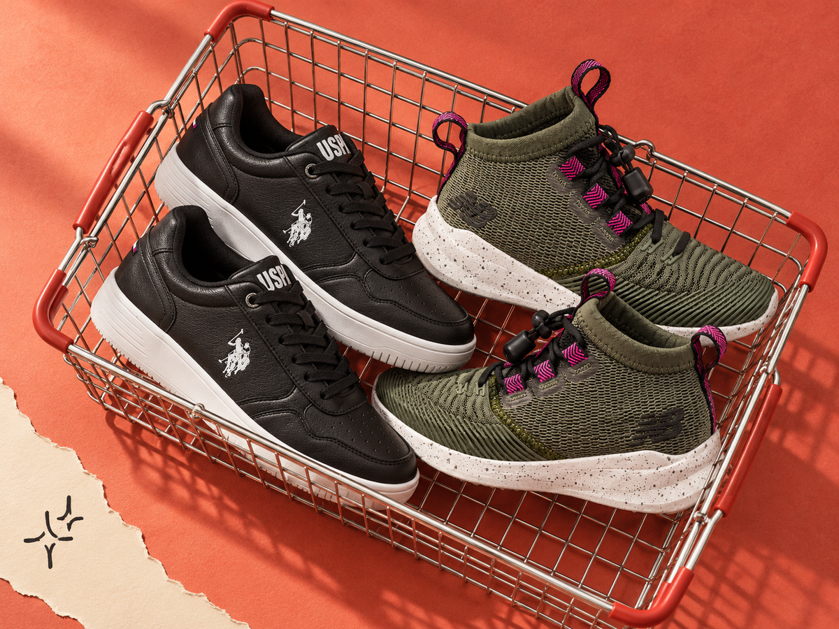 Two pairs of eligible shoes, black U.S. Polo Assn. Coster and olive New Balance Cypher Run, in a wire shopping basket on coral paper.